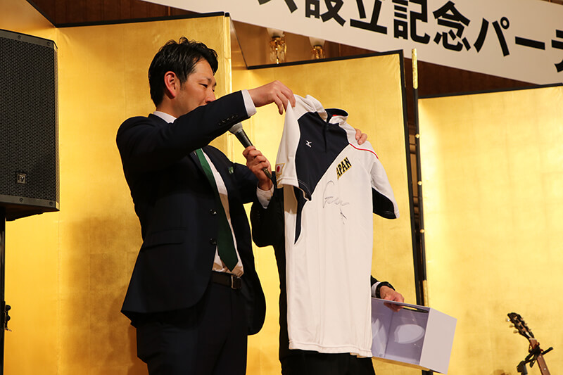 筒香選手が着ていたサムライジャパンのサイン入り練習着を持つ代表の夏凪